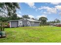 Spacious backyard with a well-maintained lawn, mature trees, and a partially fenced perimeter at 36725 Arcadia Ave, Myakka City, FL 34251