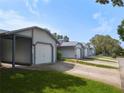 Exterior view of several one-car garages lined up, with well-maintained grass at 39650 Us Hwy 19 N, Tarpon Springs, FL 34689
