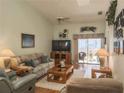 Bright living room with vaulted ceilings, ceiling fan, and sliding glass doors to patio at 39650 Us Hwy 19 N, Tarpon Springs, FL 34689