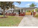 Charming two-story home with white siding, red brick accents, front porch, and covered carport at 400 E Jean St, Tampa, FL 33604
