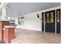 Spacious front porch featuring a swing, red brick base, and a front door with glass windows at 400 E Jean St, Tampa, FL 33604
