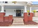 Charming front porch with red brick base, stone steps, and covered ceiling at 400 E Jean St, Tampa, FL 33604