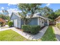 Charming home with attached garage, blue siding, lush landscaping and a well-manicured lawn at 4418 Pine Meadow Ct, Tampa, FL 33624