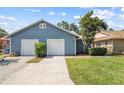 Exterior view of home with attached two-car garage, driveway, and well-maintained landscaping at 4418 Pine Meadow Ct, Tampa, FL 33624