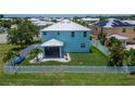 Rear view of the home featuring a screened-in porch and a well-maintained, fenced-in yard at 449 Bahama Grande Blvd, Apollo Beach, FL 33572