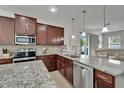 Modern kitchen with granite countertops, stainless steel appliances, and dark wood cabinetry at 449 Bahama Grande Blvd, Apollo Beach, FL 33572