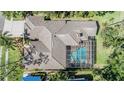 Aerial view of a private home with a screened pool, tile roof, and lush green landscaping surrounding the property at 5029 Camberley Ln, Oldsmar, FL 34677