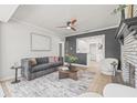 Stylish living room with a gray sofa, ceiling fan, and a brick fireplace, creating a comfortable and inviting space at 5622 Tangerine S Ave, Gulfport, FL 33707