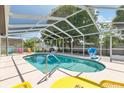 Screened-in pool area with lounge chairs and a basketball hoop, perfect for outdoor enjoyment at 5812 Blossom Ave, Tampa, FL 33614