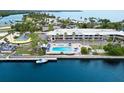Aerial view of waterfront condos with a community pool, lush landscape, and boat access at 611 Destiny Dr, Ruskin, FL 33570