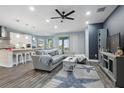 Open-concept living area showcasing a modern kitchen, stylish decor, and a comfortable gray sectional sofa at 6416 Grenada Island Ave, Apollo Beach, FL 33572