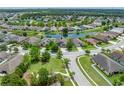 An aerial view of a well-maintained home near a pond in a tranquil neighborhood setting at 6957 Boulder Run Loop, Wesley Chapel, FL 33545