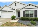 Inviting home exterior with a well-maintained lawn, dark shutters, and a clean, modern design at 7639 Broad Pointe Dr, Zephyrhills, FL 33540