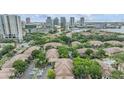 Aerial view of a residential community with lush greenery, rooftops, parking lots, and the city skyline in the background at 820 Normandy Trace Rd, Tampa, FL 33602
