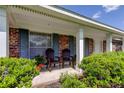 Inviting front porch with blue shutters, adorned with chairs and vibrant plants, offering curb appeal at 9918 Davis Rd, Tampa, FL 33637