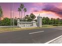A stone sign reads 'Island Estates', with palm trees beneath a colorful sunset at 105 Island Way # 126, Clearwater Beach, FL 33767