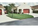 Charming single-story home with well-manicured lawn and a red garage door creating curb appeal at 11541 Orleans Ln, Port Richey, FL 34668