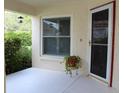 Inviting covered front porch with a potted plant and window, creating a cozy outdoor space at 11541 Orleans Ln, Port Richey, FL 34668