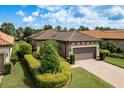 Well-maintained exterior showcases a tile roof, manicured landscaping, and an attached two-car garage at 11551 Callisia Dr, Odessa, FL 33556