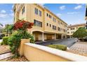 Rear exterior view showing multiple garage spaces and upper floors on sunny day at 119 Beach Haven Ln, Tampa, FL 33609