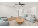 Spacious living room with wood-look floors, ceiling fan, and comfortable gray seating at 1713 W Saint John St, Tampa, FL 33607