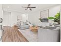 Bright living room features a ceiling fan, wood-look flooring, a cozy sectional, and a stylish rug at 1713 W Saint John St, Tampa, FL 33607