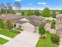 An aerial view of a well-landscaped home with a brick patio nestled among mature trees and neighboring houses at 18620 Rococo Rd, Spring Hill, FL 34610