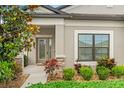Inviting front entrance with a decorative glass door and colorful landscaping enhances curb appeal at 18620 Rococo Rd, Spring Hill, FL 34610