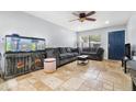 Open-concept living room featuring an aquarium, travertine floors, and a comfortable grey sofa at 1881 N Hercules Ave # 602, Clearwater, FL 33765