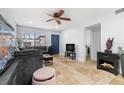 Well-lit living room featuring travertine floors, a comfortable grey sofa, and access to the rest of the home at 1881 N Hercules Ave # 602, Clearwater, FL 33765
