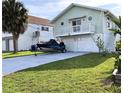 Charming two-story home with a well-manicured lawn and a two-car garage underneath the main level at 3312 Holly Springs Dr, Hernando Beach, FL 34607