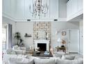 Bright living room with tall ceilings, fireplace, modern chandelier, and neutral decor at 33560 Castaway Loop, Wesley Chapel, FL 33543