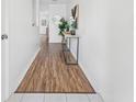 Bright hallway with hardwood floors, decorative table, and doorways ahead at 4149 Winding River Way, Land O Lakes, FL 34639