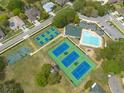 Aerial view of community pool, basketball court, tennis courts, and surrounding neighborhood at 4228 Silver Star Dr, Spring Hill, FL 34609