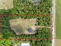 An aerial shot shows the location of the home on a large lot surrounded by lush greenery and a nearby road at 4261 Burns Rd, Brooksville, FL 34602