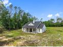 Exterior angle of the house showing the porch, white siding, and surrounding landscape under a clear sky at 4261 Burns Rd, Brooksville, FL 34602