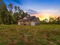 Beautiful exterior shot showcasing the home, front yard, and sunset sky; highlighting the home's setting at 4261 Burns Rd, Brooksville, FL 34602