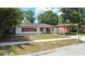 Charming one-story home with brick accents, a cozy carport, and a well-maintained lawn at 4425 Porpoise Dr, Tampa, FL 33617