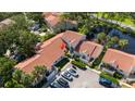 An aerial view of a tranquil community near a lake featuring terra cotta roofs, mature trees, and serene landscaping at 4783 Palermo Ne Ct # 4783, St Petersburg, FL 33703