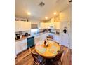 Bright kitchen featuring white cabinets, stainless appliances, a breakfast nook, and wood look vinyl flooring at 5351 Leisure Ln, New Port Richey, FL 34652