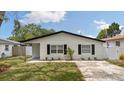 Inviting single-story home with a fresh lawn and black shutters at 621 89Th N Ave, St Petersburg, FL 33702