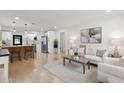 Open-concept living room with modern decor, wood floors, kitchen access, and abundant natural light at 621 89Th N Ave, St Petersburg, FL 33702
