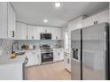 Bright kitchen with white cabinets, stainless steel appliances, quartz countertops and hardwood floors at 6738 Criswell N Ave, St Petersburg, FL 33709