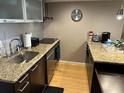 The kitchen features stone countertops, stainless appliances and wood floors at 701 S Madison Ave # 515, Clearwater, FL 33756