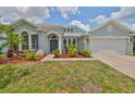 Charming home featuring a three-car garage, beautiful landscaping, and a welcoming entrance at 7114 Cromwell Park Ln, Apollo Beach, FL 33572