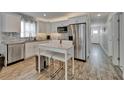 Modern kitchen featuring stainless steel appliances, white cabinets, granite countertops, a mosaic backsplash, and eat-in table at 719 58Th S St, Gulfport, FL 33707
