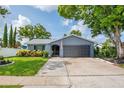 Beautiful single-story home featuring well-maintained landscaping, a gray two-car garage, and an American flag at 7444 119Th Ave, Largo, FL 33773