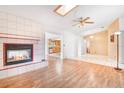 Open-concept living room with a cozy fireplace, ceiling fan, and skylight with views to dining room at 7444 119Th Ave, Largo, FL 33773