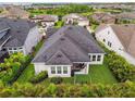 Aerial view of the backyard showing a well-maintained lawn and lush tropical landscaping, with a play set at 7616 Paradiso Dr, Apollo Beach, FL 33572