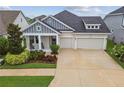 Charming single Gathering home with a three-car garage, inviting front porch, and beautiful landscaping at 7616 Paradiso Dr, Apollo Beach, FL 33572